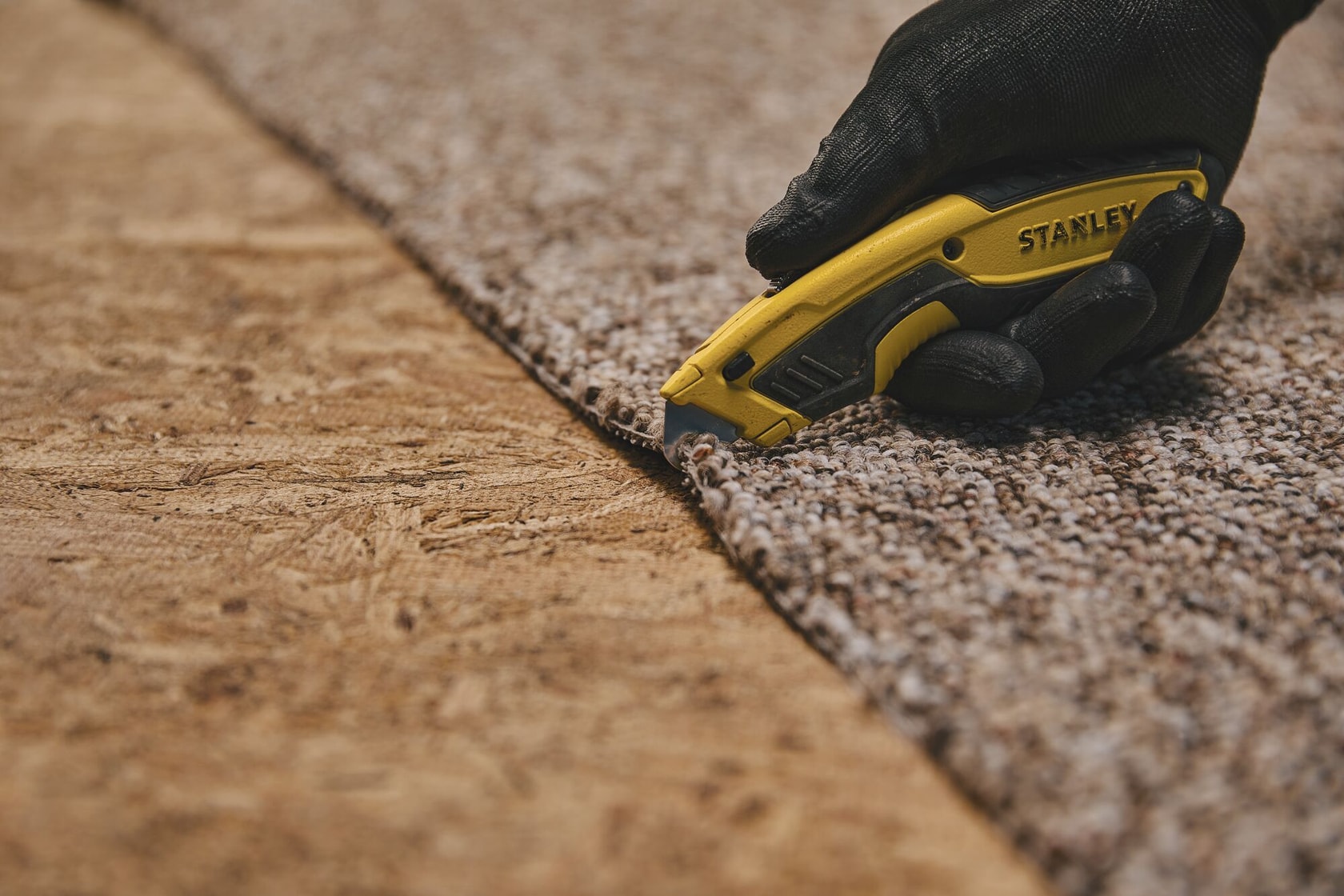 Retractable Utility Knife being used for cutting carpet.